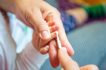 Mother is cutting nail.