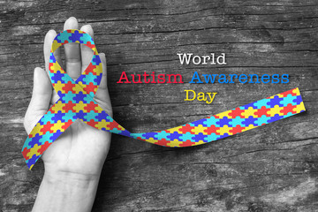 World Autism awareness day with Puzzle ribbon on person's hand