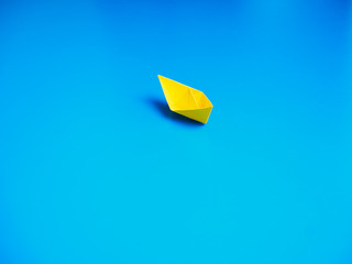 Paper boat on blue paper background