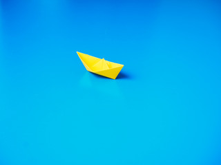 Paper boat on blue paper background