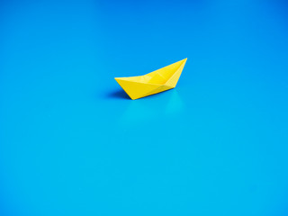 Paper boat on blue paper background