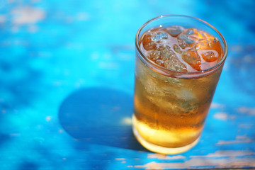 Ice tea on blue rustic wooden table. Selective focus and free space for text.