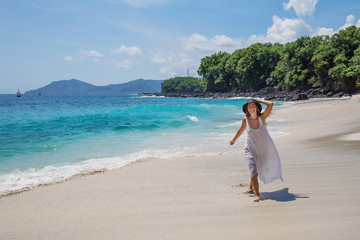 Happy  woman in white dress on tropical beach vacation