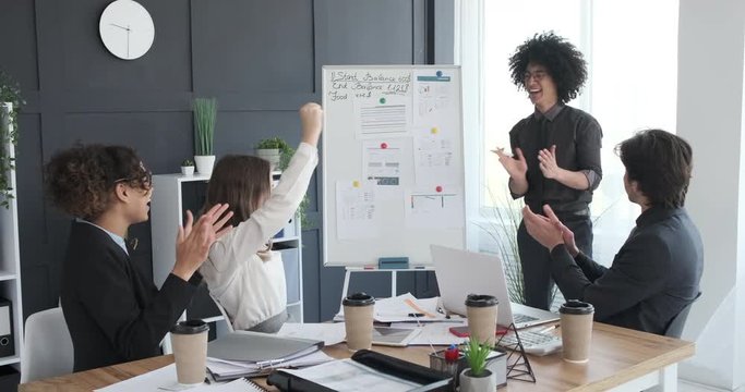 Happy business people clapping hands in a conference room