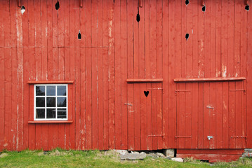 red wooden barn wall with window and door with a heart