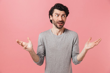 Young confused bearded brunette man