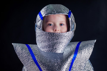 Little girl in foil diy space suit on a black background in the studio July 20, 1969 day of landing...