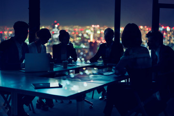 Businessmen that work together in office at night. concept of teamwork and partnership.
