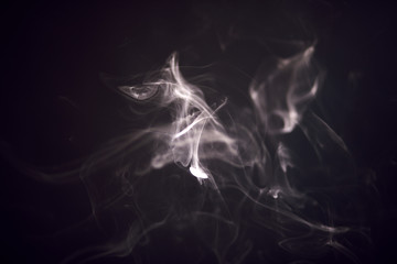 White smoke isolated on black background, fancifully spreads in the air. Monochrome.