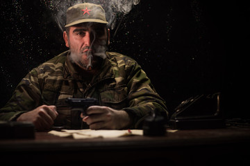 The evil dictator sitting on table. Angry communist general sitting at headquarter or Cuban...