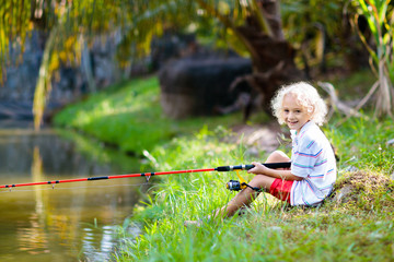 Boy fishing. Child with rod catching fish in river