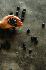 Hands Holding Organic Blueberries on Dark Background. Superfood Healthy Eating Concept.