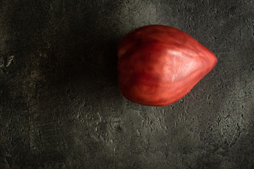 Organic Heirloom Tomato on Rustic Dark Background. Red Bull's Heart.