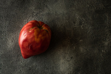 Organic Heirloom Tomato on Rustic Dark Background. Red Bull's Heart.
