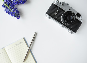 Bright Interesting background table for the site. Details on the table: Notepad, pen, camera, flowers. Background traveler and photographer.