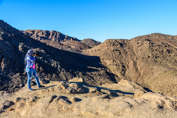 Young woman taking a photo in Arabian desert not far from the Hurghada city, Egypt
