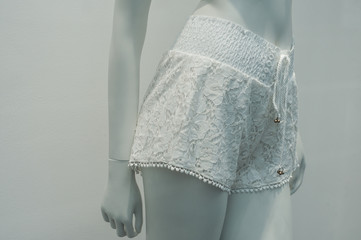 closeup of white shorty on mannequin in fashion store showroom for women