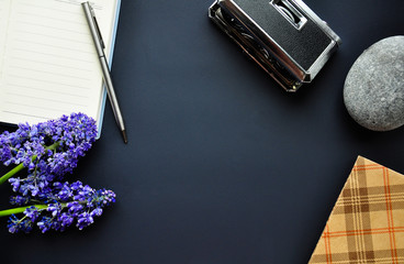 Interesting background for the site. Notebook, pen, theater binoculars, flowers, art. Details and elements on the edges of the table.