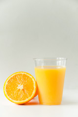 Fresh orange juice in a glass. Round orange slices on a white background. Citrus tropical fruit background. Bright food. Dietary vitamin nutrition. A lot of vitamin C.