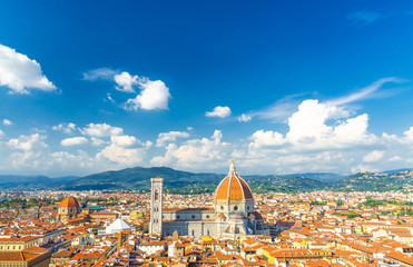 Fototapeta na wymiar Top aerial panoramic view of Florence city with Duomo Cattedrale di Santa Maria del Fiore cathedral, buildings houses with orange red tiled roofs and blue sky white clouds, copy space, Tuscany, Italy