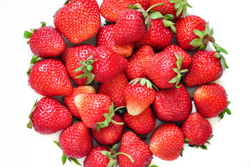 A lot of strawberry berries on a white background. A group of sweet fruits. Vitamin fruits for smoothies, cocktails and preserves. Natural products for healthy nutrition for vegetarians.