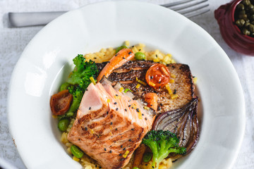 Roasted Salmon Fillet with Vegetables on Rustic White Plate. Healthy Food Concept.
