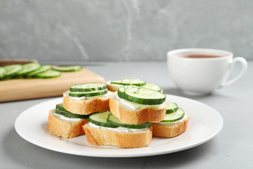 Plate with traditional English cucumber sandwiches on table. Space for text