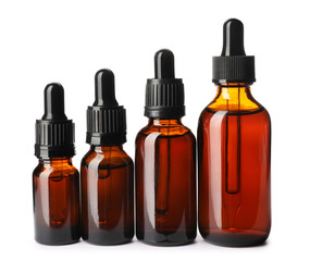 Cosmetic bottles of essential oils on white background
