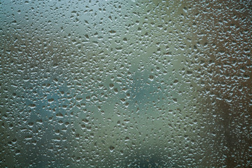 Background or texture. It is a lot of small a rain drops on window glass. Rainy day of spring.