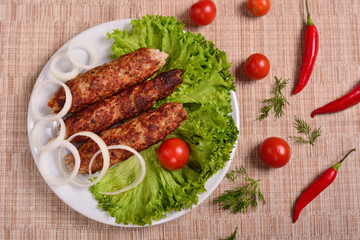 Lula kebab is a traditional Arabic dish. Meat shashlik on  with tomato. The top view