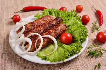 Lula kebab is a traditional Arabic dish. Meat shashlik on  with tomato.