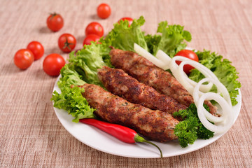 Lula kebab is a traditional Arabic dish. Meat shashlik on  with tomato.