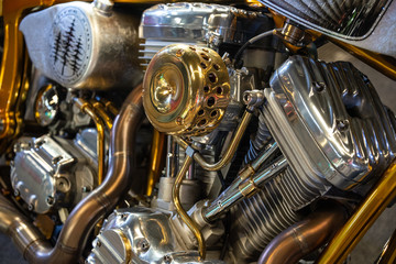 Detail of the motor of v engine of a chrome motorcycle in silver and gold colors