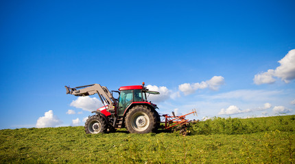 Tracteur préparant les foins dans la campagne en France