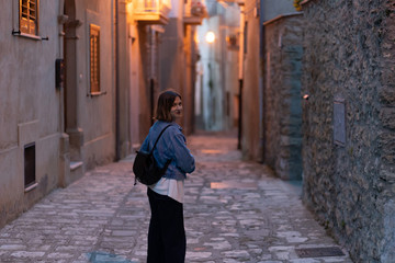Fototapeta na wymiar handsome tourist girl visiting narrow streets of old town in southern Italy, Basilicata Apulia region