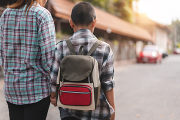 Mother or parent holding hand son or pupil with backpack go to school, Back to school concept, Selective focus.