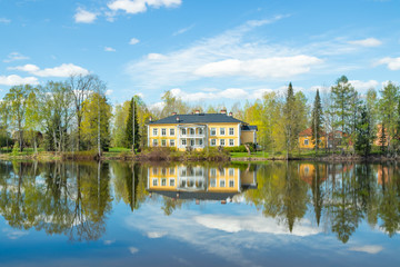 Fototapeta premium Kouvola, Finland - May 16, 2019: Beautiful wooden Rabbelugn Manor - Takamaan Kartano. Wrede family house was built in 1820 on the river Kymijoki bank.