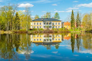 Fototapeta premium Kouvola, Finland - May 16, 2019: Beautiful wooden Rabbelugn Manor - Takamaan Kartano. Wrede family house was built in 1820 on the river Kymijoki bank.