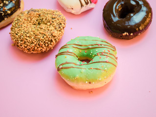Donuts assorted with glazed on blue and pink background