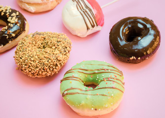 Donuts assorted with glazed on blue and pink background