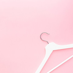 White hangers on pastel pink background