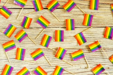 Bright rainbow gay flag on wooden background, top view LGBT community