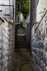 View of narrow street with stairs and stone walls