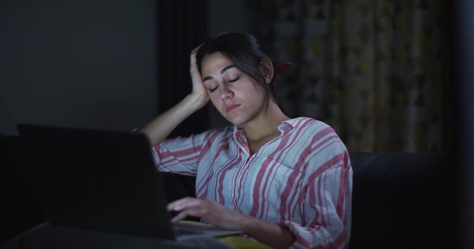 4K Young woman working late on computer & struggling to stay awake