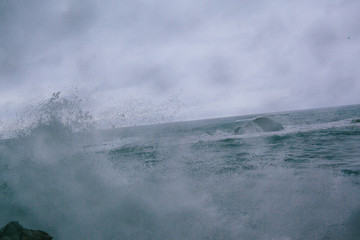 Waves of a raging dark sea crashing on rocks