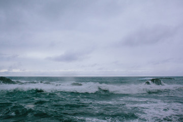 Waves of a raging dark sea crashing on rocks