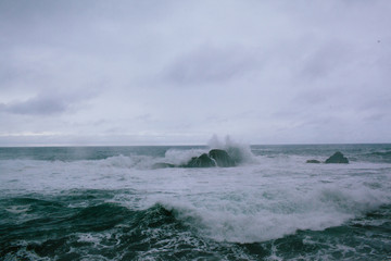 Waves of a raging dark sea crashing on rocks