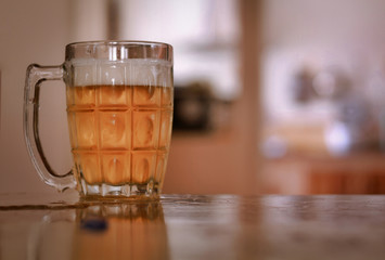glass of cold frothy lager beer on an old wooden table