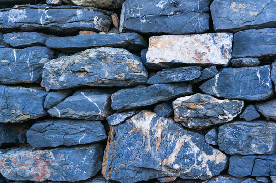 Background of a traditional dry stone wall from Porto Venere, Italy. Sedimentary rocks, argillite, stacked.