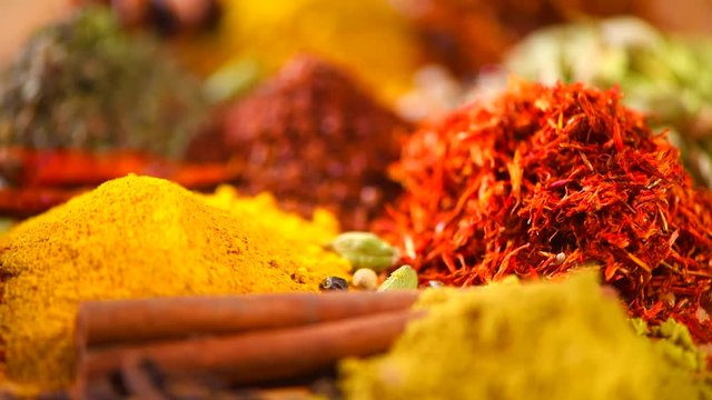 Spice. Various Indian spices and herbs rotated on wooden table. Rotation. Slow motion 4K UHD video 3840X2160